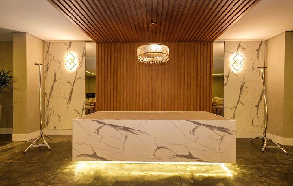 Espaço central do cerimonial com revestimento claro e painel de madeira